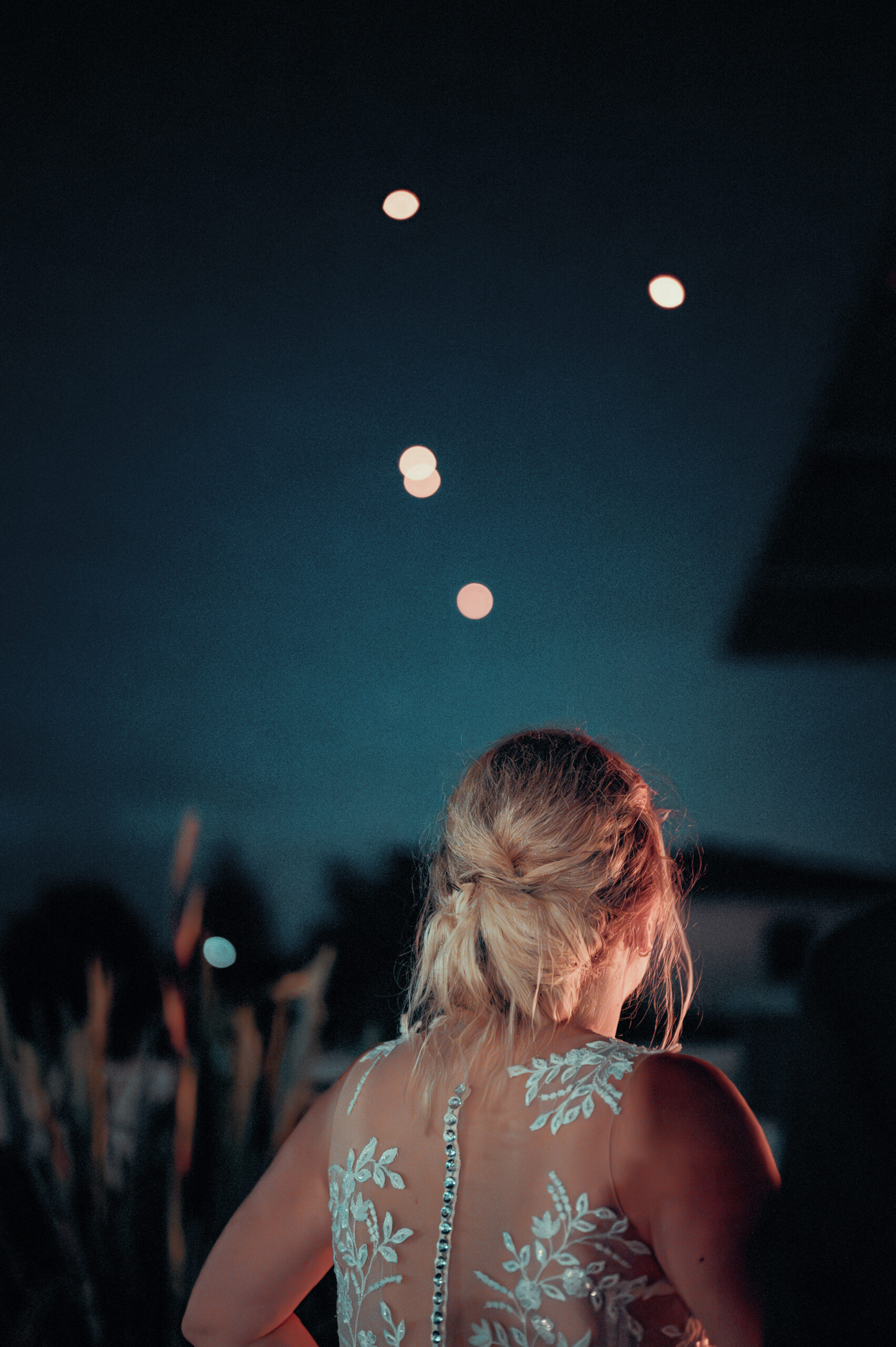 Claire, la mariée de dos, admirant les lanternes s'envoler dans le ciel étoilé de Seyssuel, près de Vienne