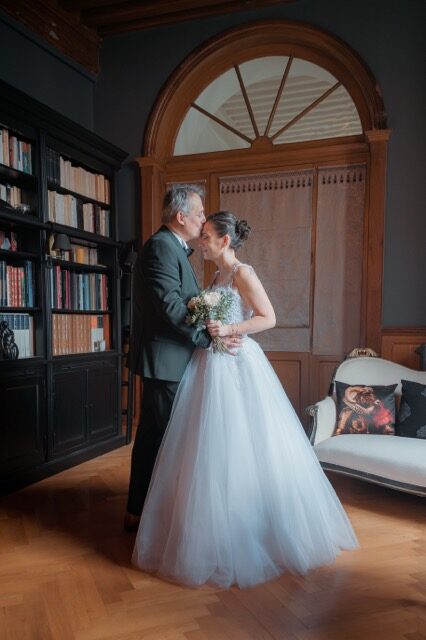 Mariés s'embrassant dans la bibliothèque d'un château lors d'un mariage photographié par Kaïto Rimbaud