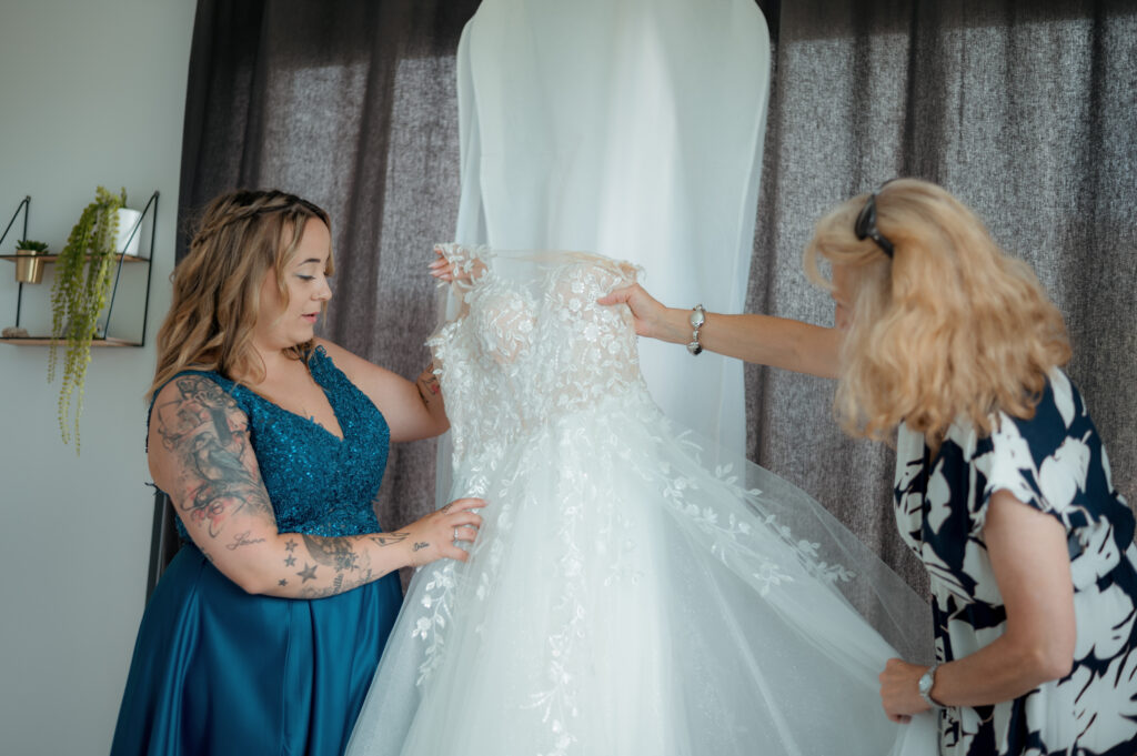 Préparatifs de la mariée dans l'Ain – robe de mariée en dentelle présentée par deux proches