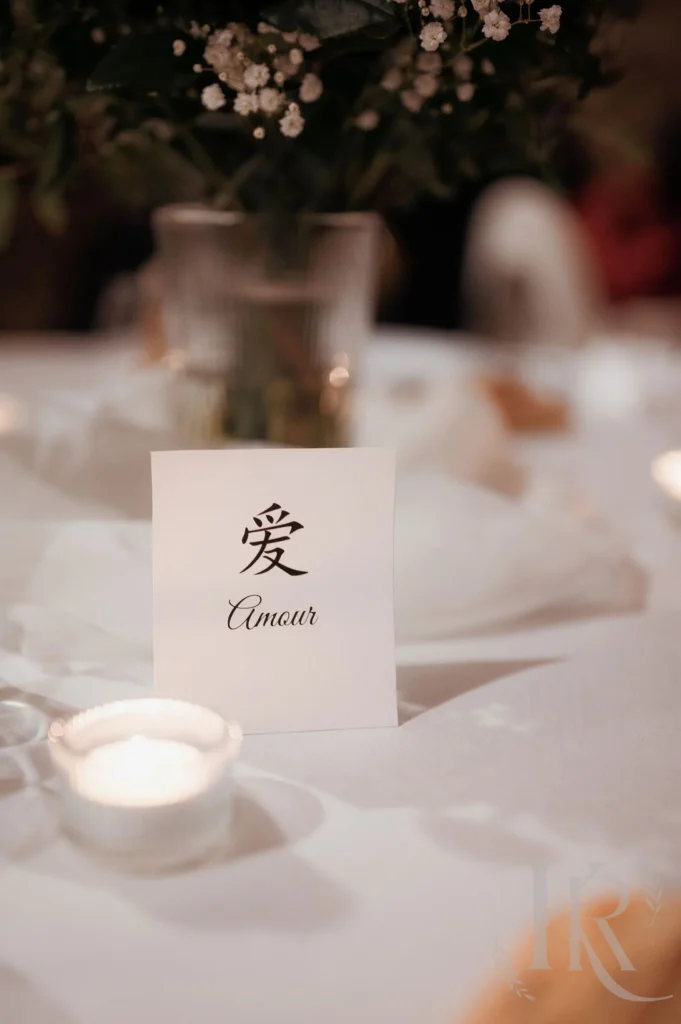 Carton mariage avec caractères asiatiques amour sur table blanche décorée bougies