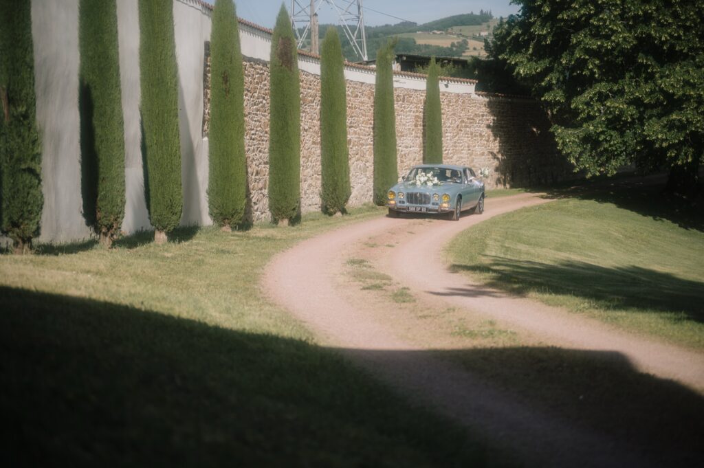 La Jaguar des mariés remonte l'allée des cyprès du Château de Laforest, mariage à Thizy-les-Bourgs, Kaïto Rimbaud photographe