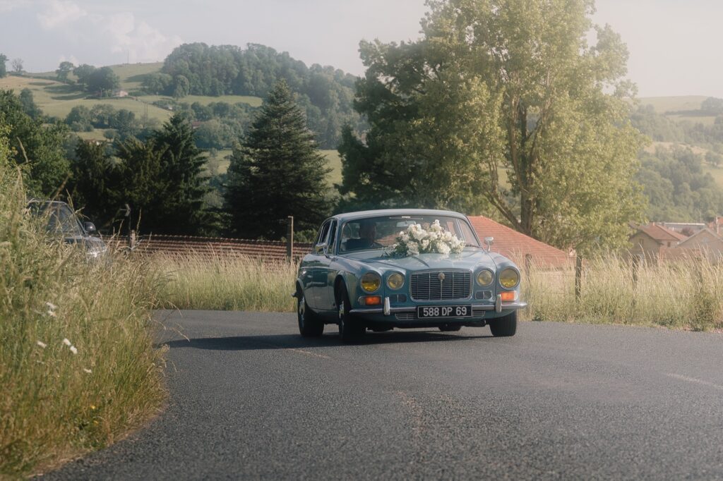 La Jaguar restaurée des mariés en mouvement sur les routes de campagne, cortège de mariage à Thizy-les-Bourgs, Kaïto Rimbaud photographe