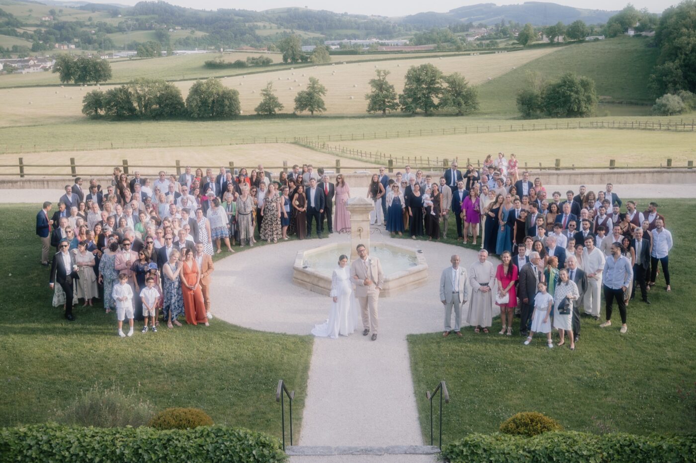 Photo de groupe de tous les invités autour de la fontaine du Château de Laforest, mariage à Thizy-les-Bourgs, Kaïto Rimbaud photographe
