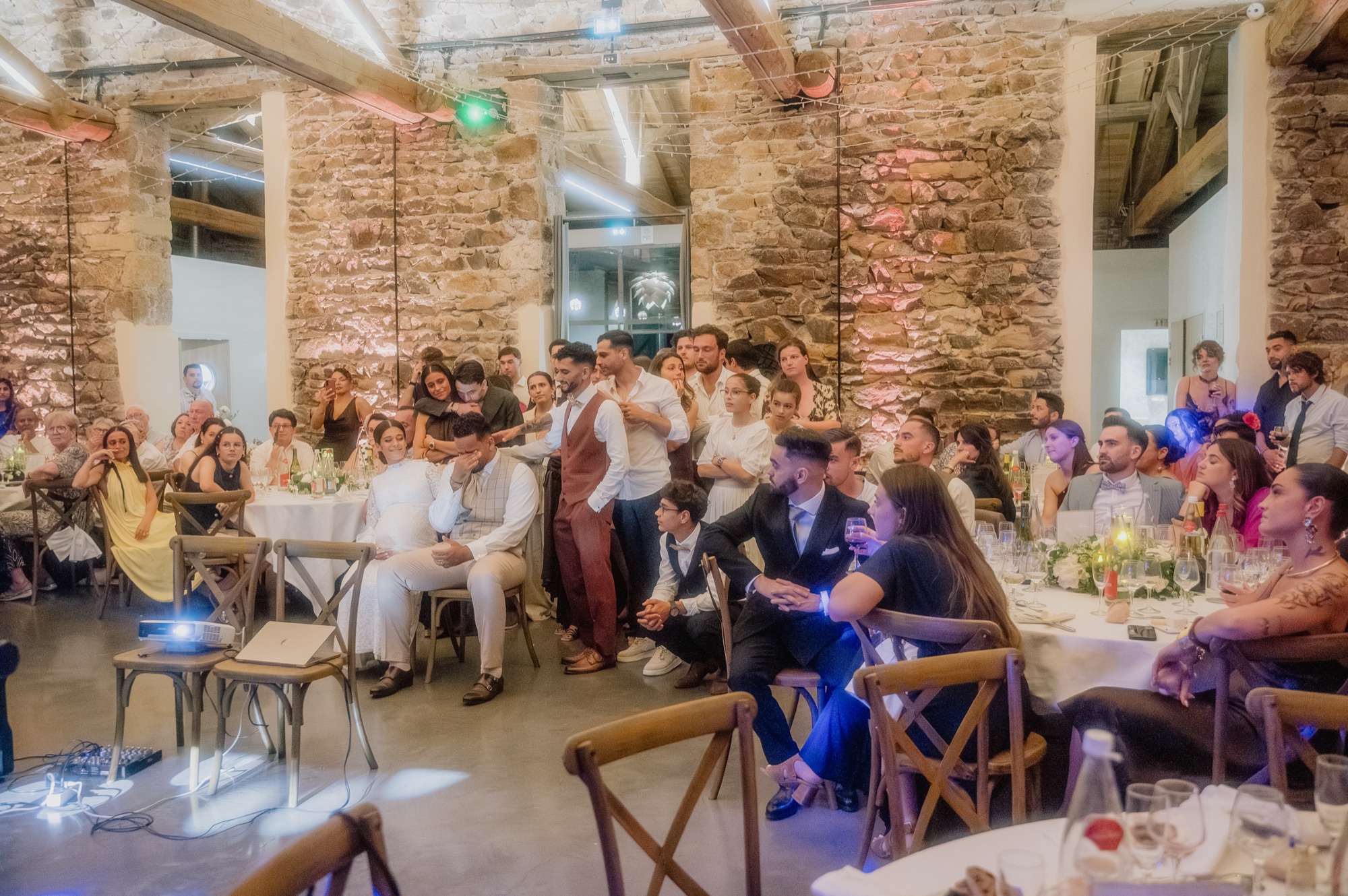 Les invités et les mariés émus pendant la projection vidéo des témoins, mariage au Château de Laforest, Thizy-les-Bourgs