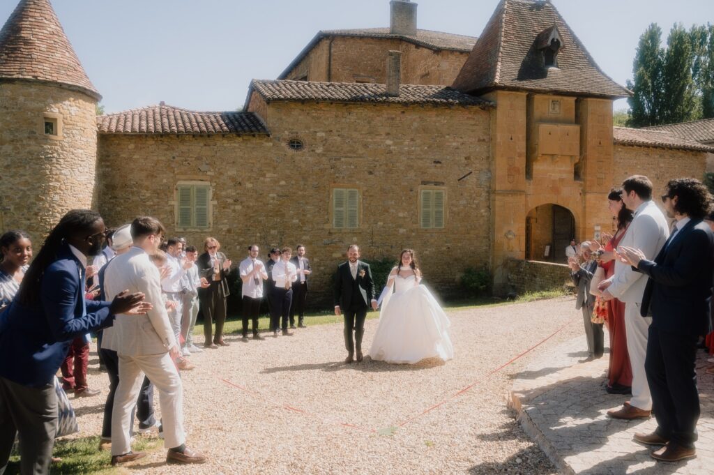 Les mariés arrivent dans la cour du Château du Sou sous les applaudissements, le ruban au sol, Lacenas, Beaujolais