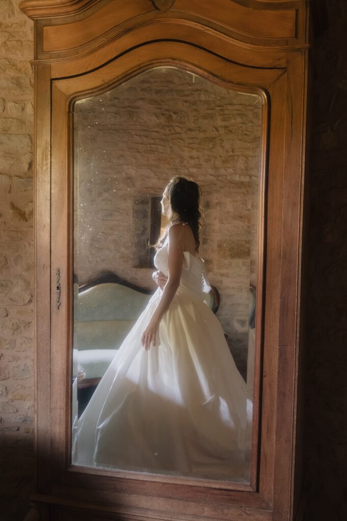 La mari&eacute;e en robe se refl&egrave;te dans un miroir ancien, pr&eacute;paratifs au Ch&acirc;teau du Sou, Lacenas, Beaujolais