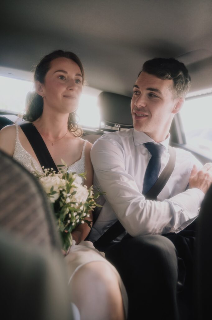Les mariés complices dans la voiture entre l'église et le Fourvière Hôtel, mariage à Lyon