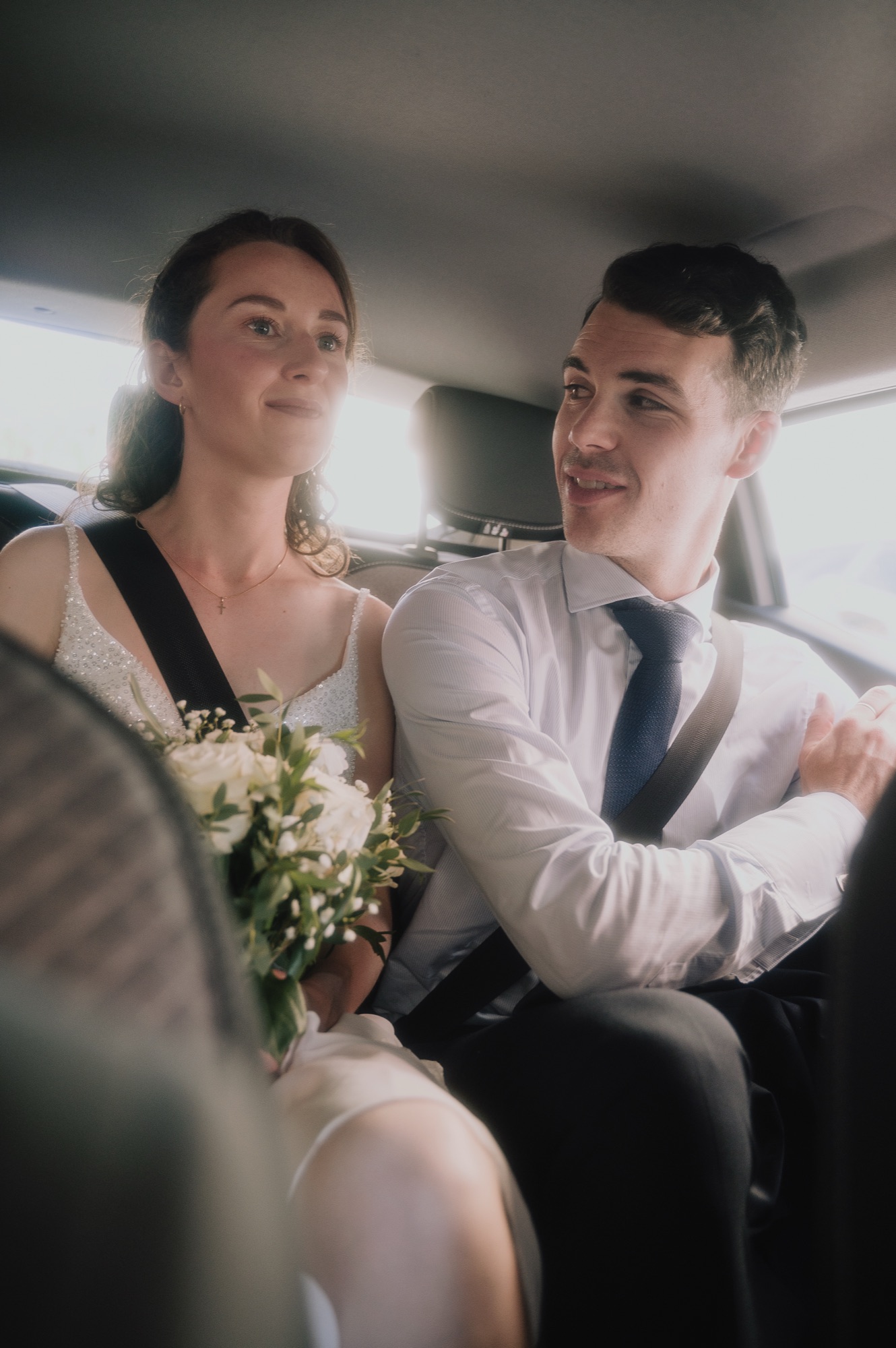 Les mariés complices dans la voiture entre l'église et le Fourvière Hôtel, mariage à Lyon