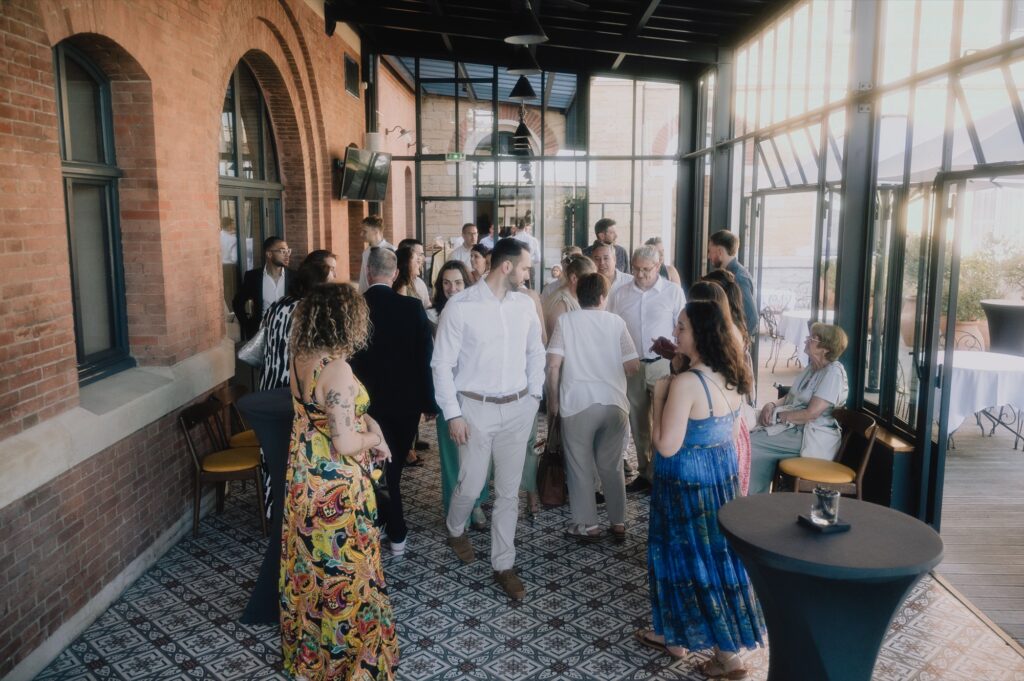 Vin d'honneur au Fourvière Hôtel, un invité trinque, mariage à Lyon, Kaïto Rimbaud photographe