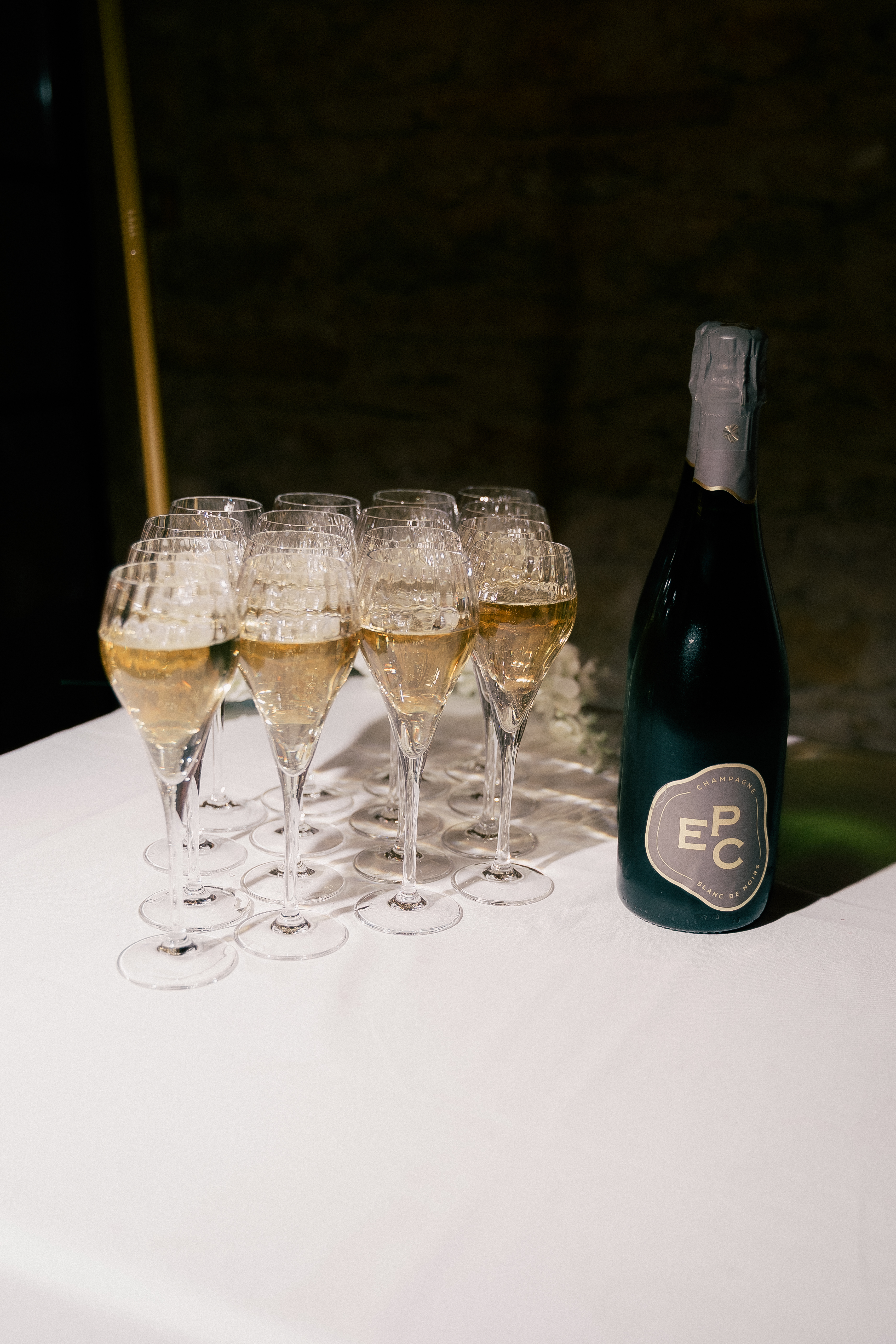 Coupes de champagne remplies align&eacute;es sur une table blanche pr&egrave;s de la bouteille, Lyon, Ka&iuml;to Rimbaud photographe
