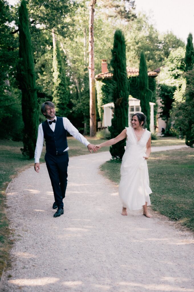 Mari&eacute;s main dans la main dans une all&eacute;e de cypr&egrave;s, Ka&iuml;to Rimbaud photographe de mariage