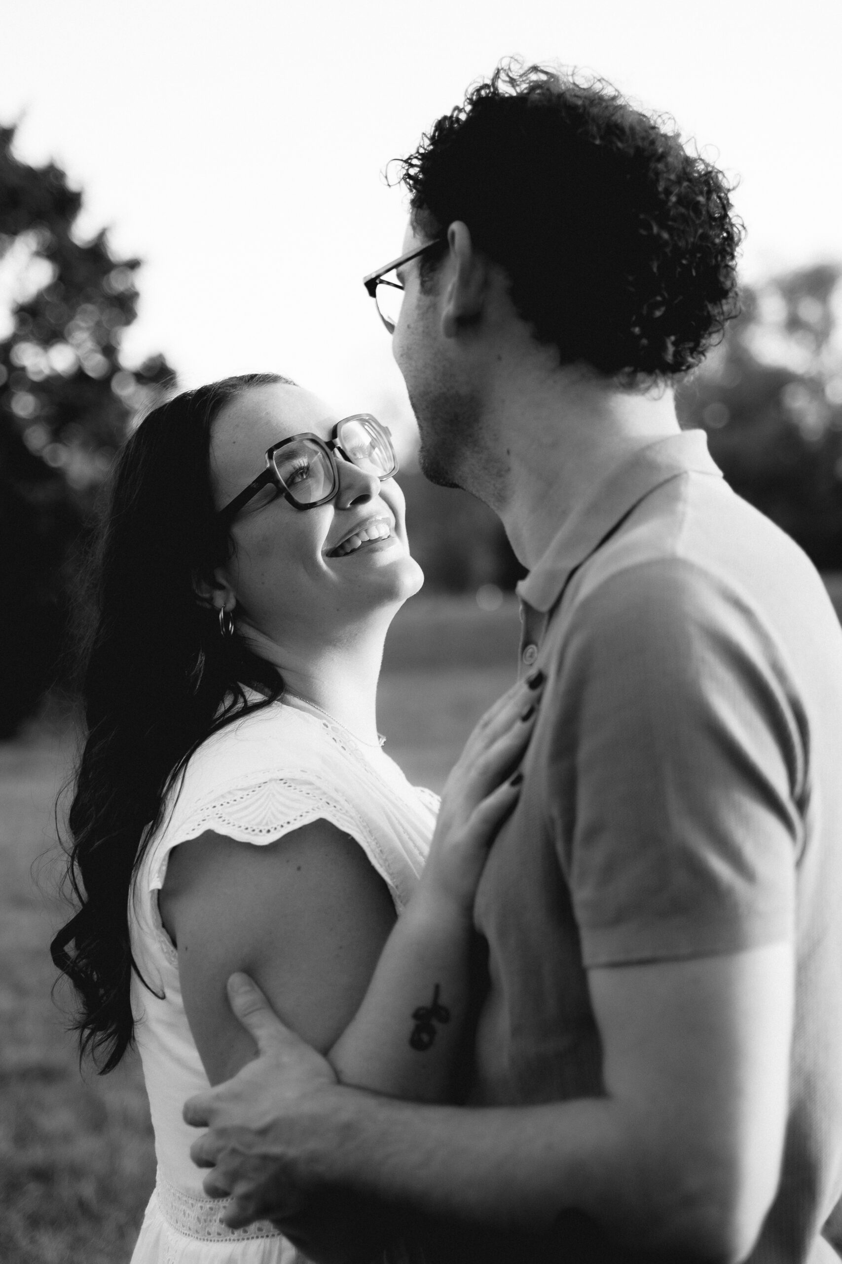 Couple souriant enlacé dans un parc en noir et blanc, Lyon, Kaïto Rimbaud photographe