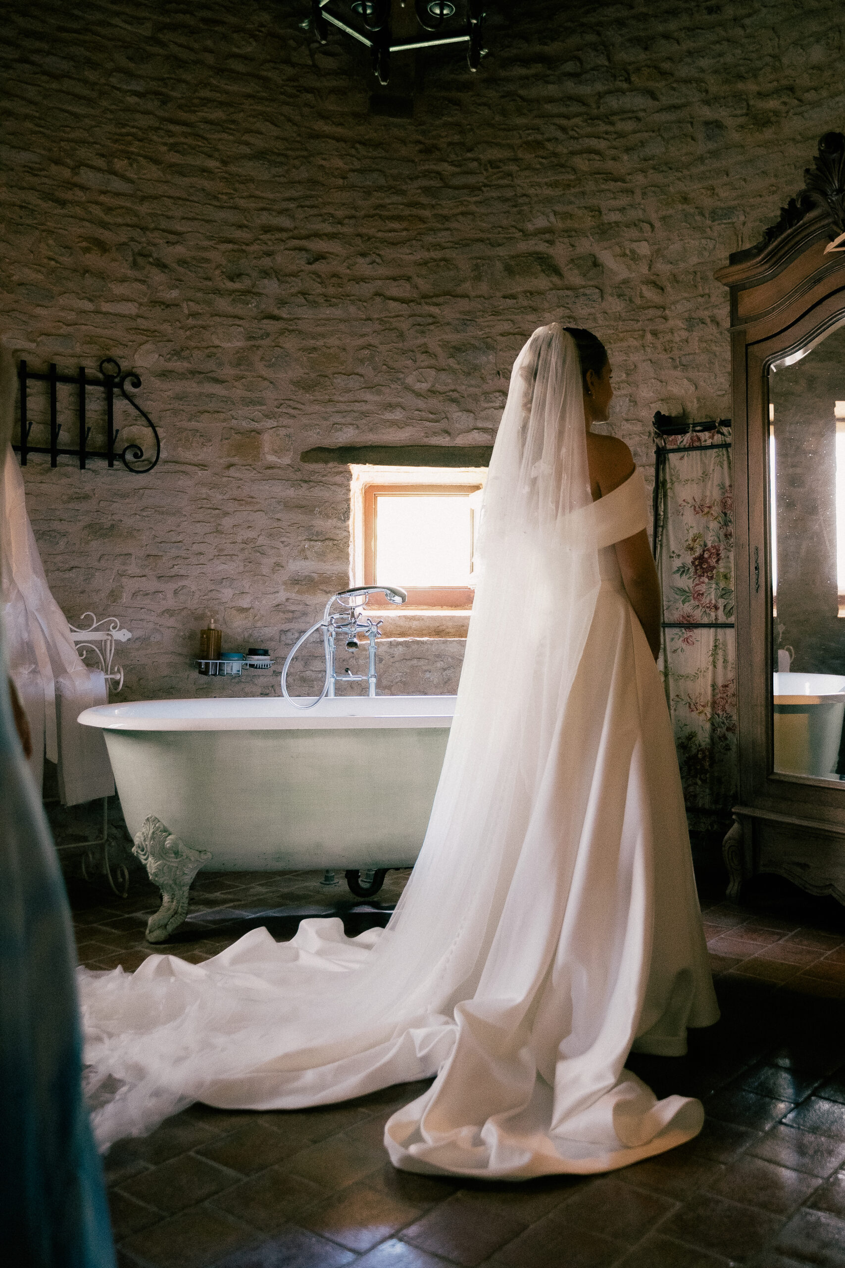 Mariée de dos, voile long et traîne devant une baignoire ancienne, Ain, Kaïto Rimbaud photographe